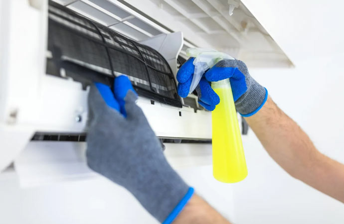 Worker cleaning mold from air conditioner